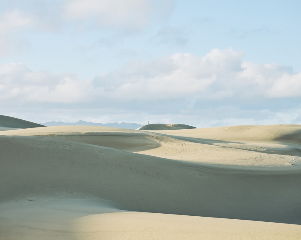 a group of sand dunes with a sky background