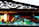 A vintage stained glass window with an ornate metal grille above it. The glass features vibrant colors including red, blue, green, and a light bulb lit on the left side, casting a warm glow. The metal grille has intricate, swirling patterns and a slightly weathered look.
