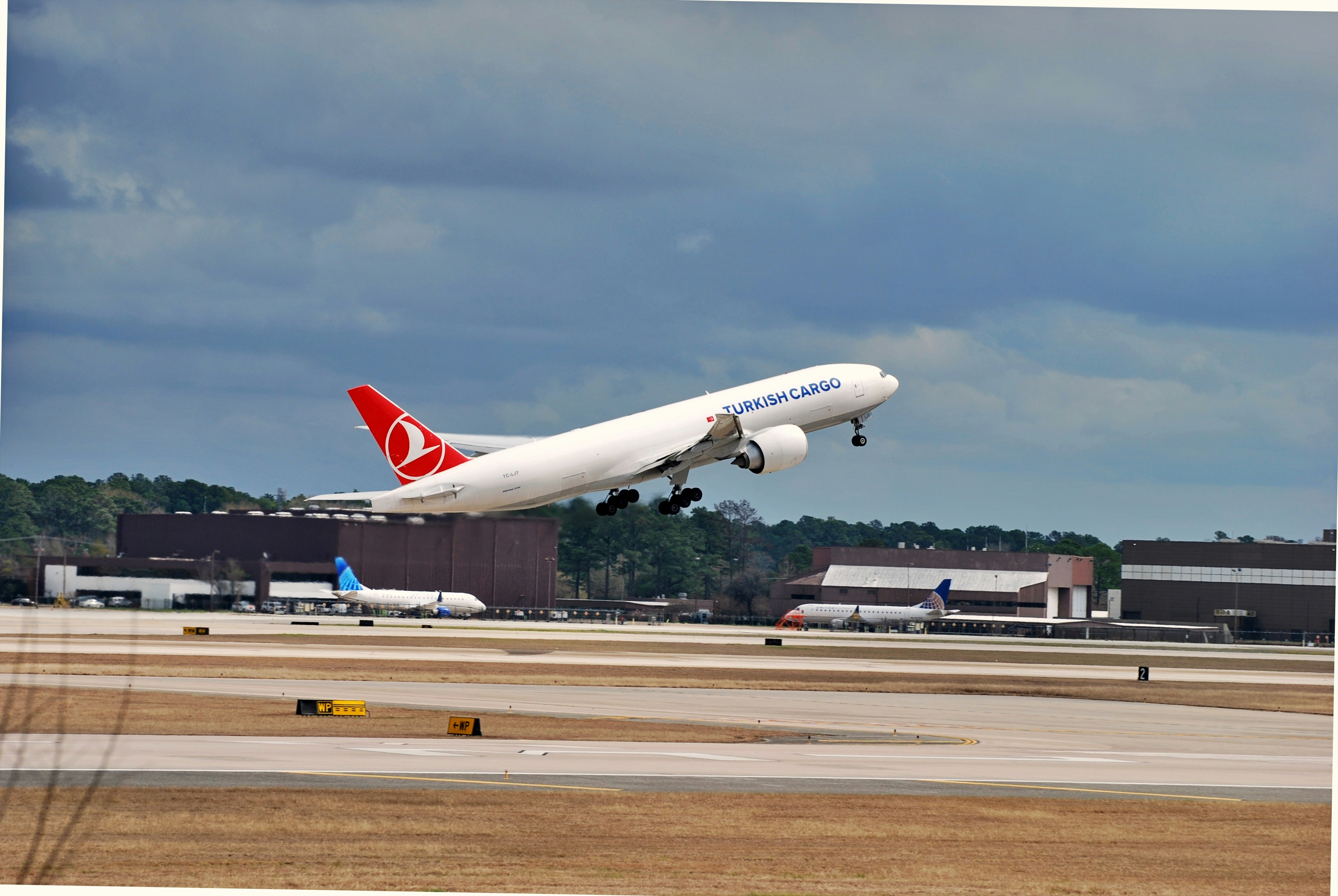 a large jetliner taking off from an airport runway, Turkish Cargo 777-F to Istanbul