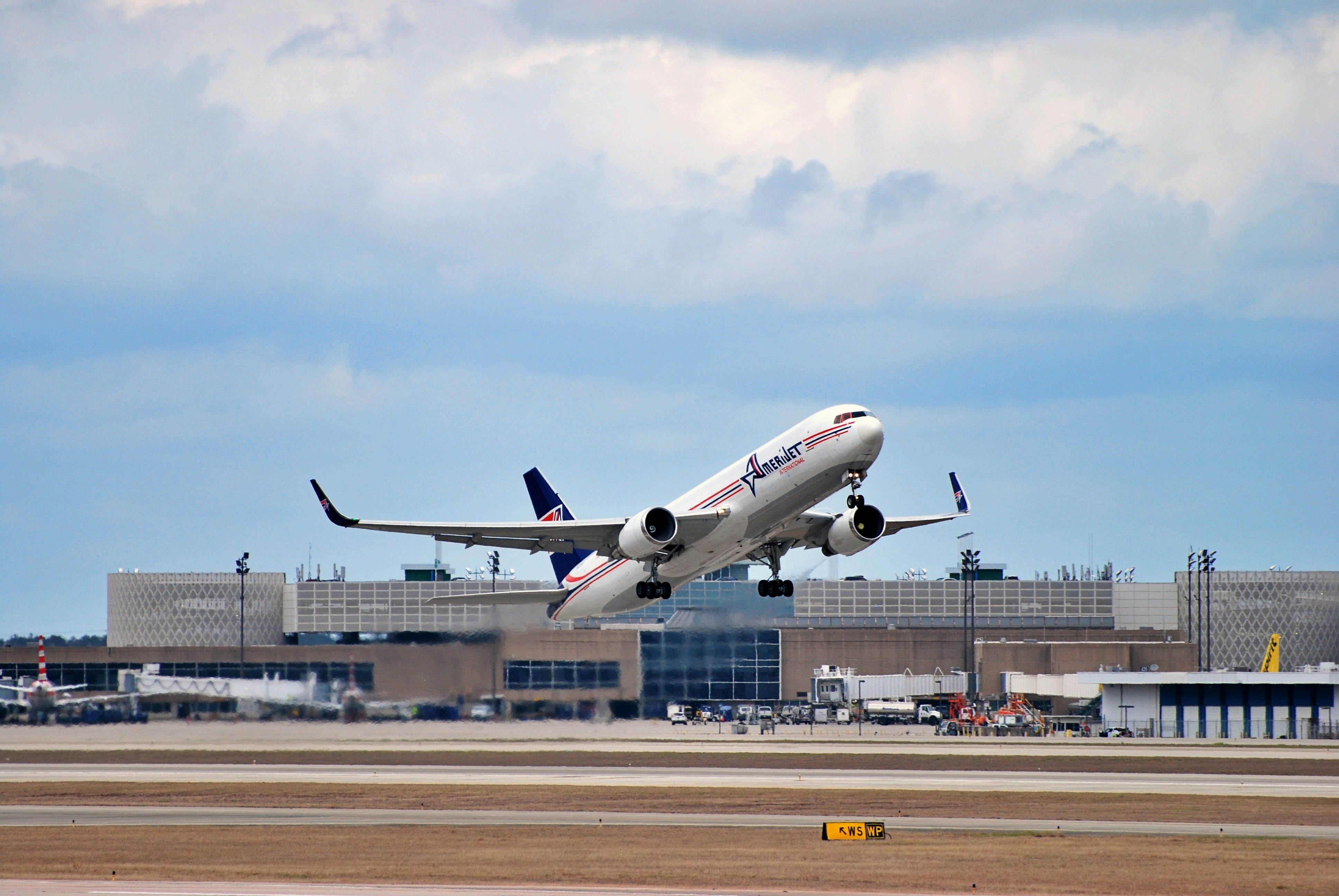 a large jetliner taking off from an airport runway, AmeriJet 767-200F out of IAH