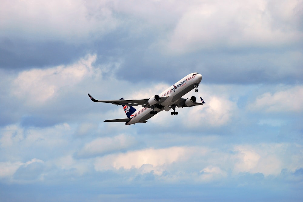 a large jetliner flying through a cloudy blue sky