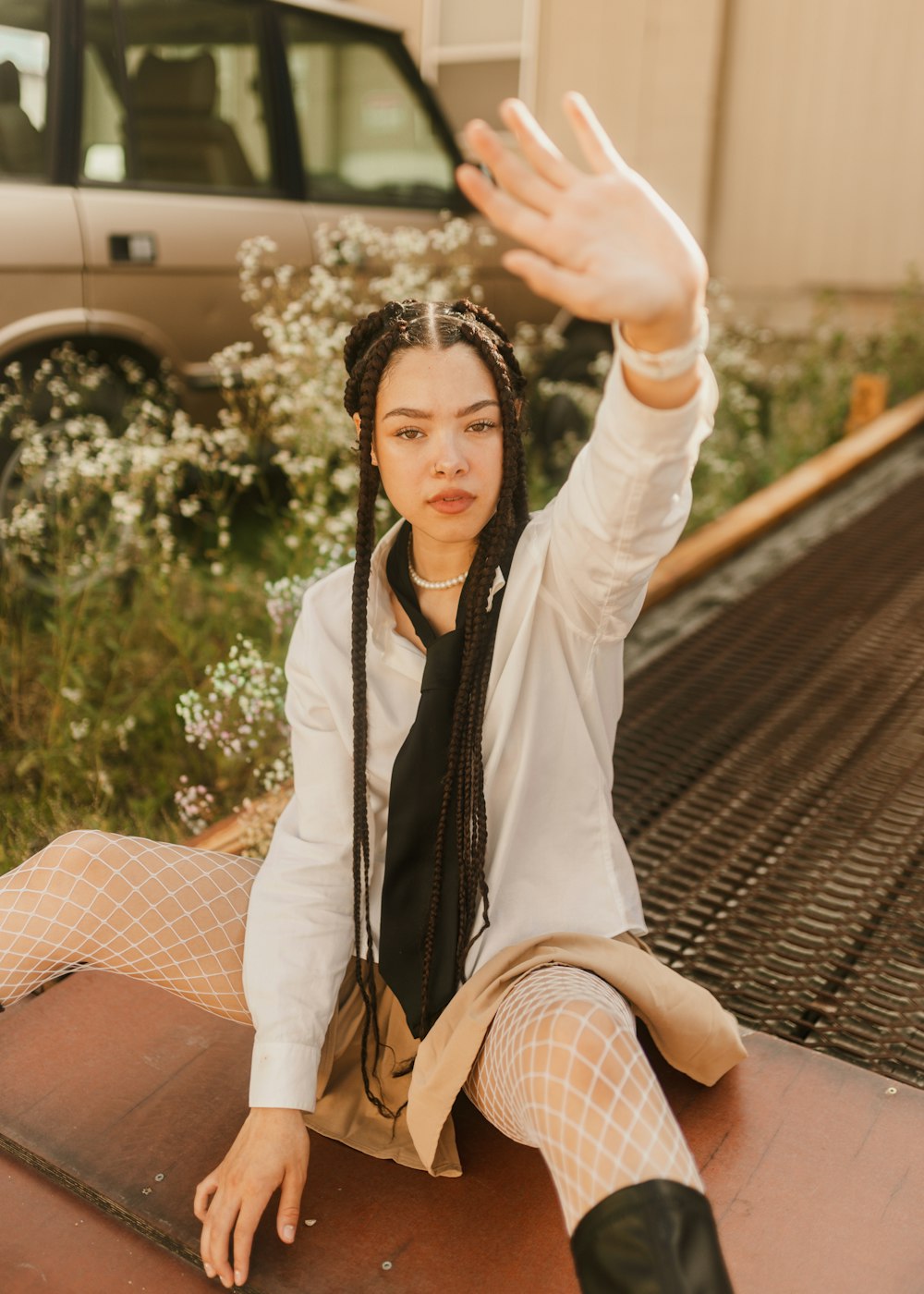 a woman sitting on the ground with her hand in the air