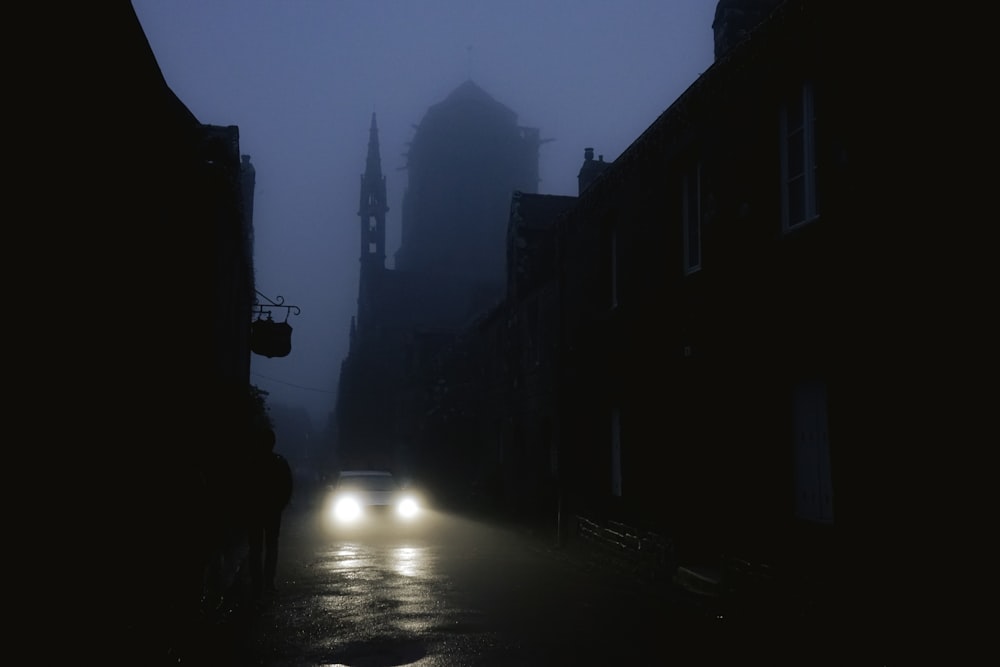 a car driving down a street in the fog