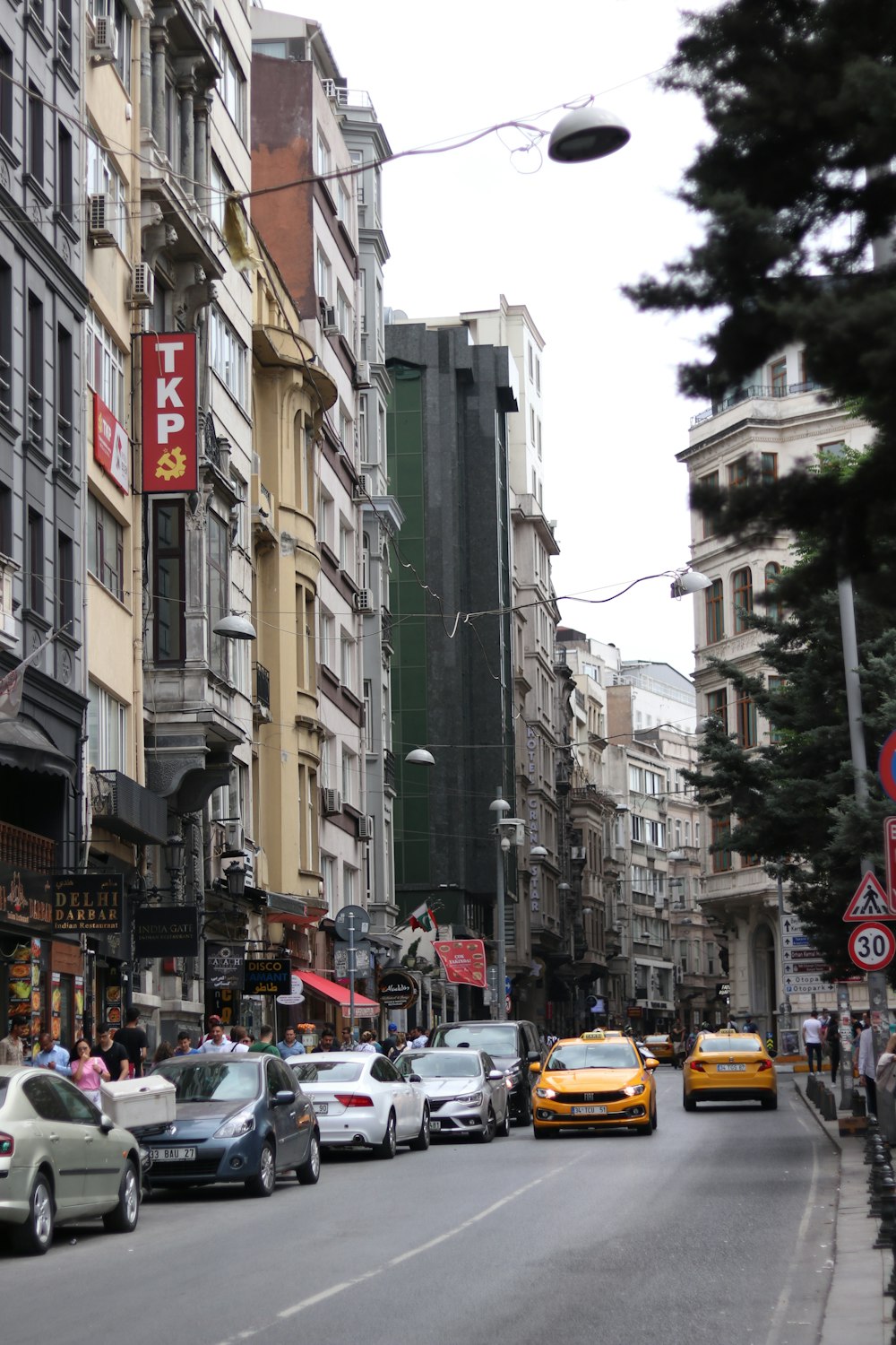 a city street filled with lots of traffic next to tall buildings