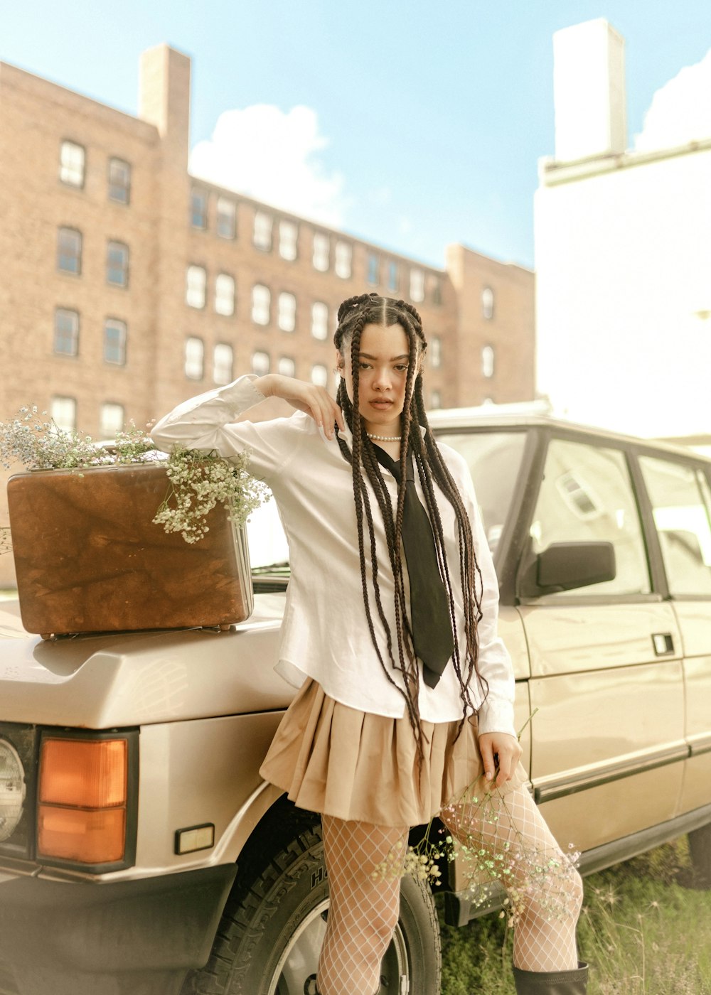 a woman with dreadlocks standing next to a car