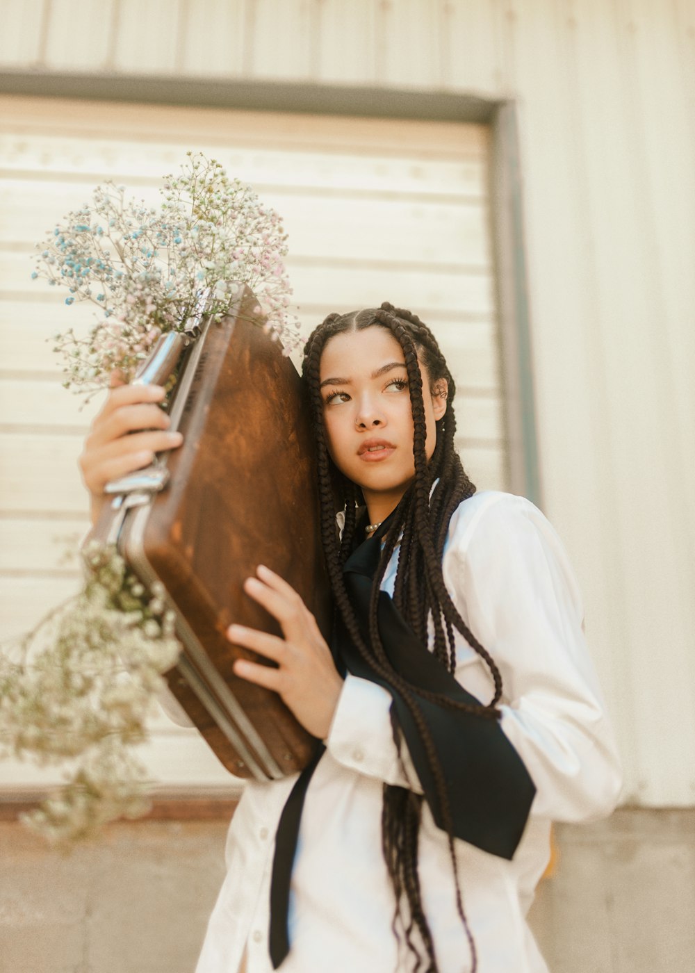 a woman with dreadlocks holding a suitcase