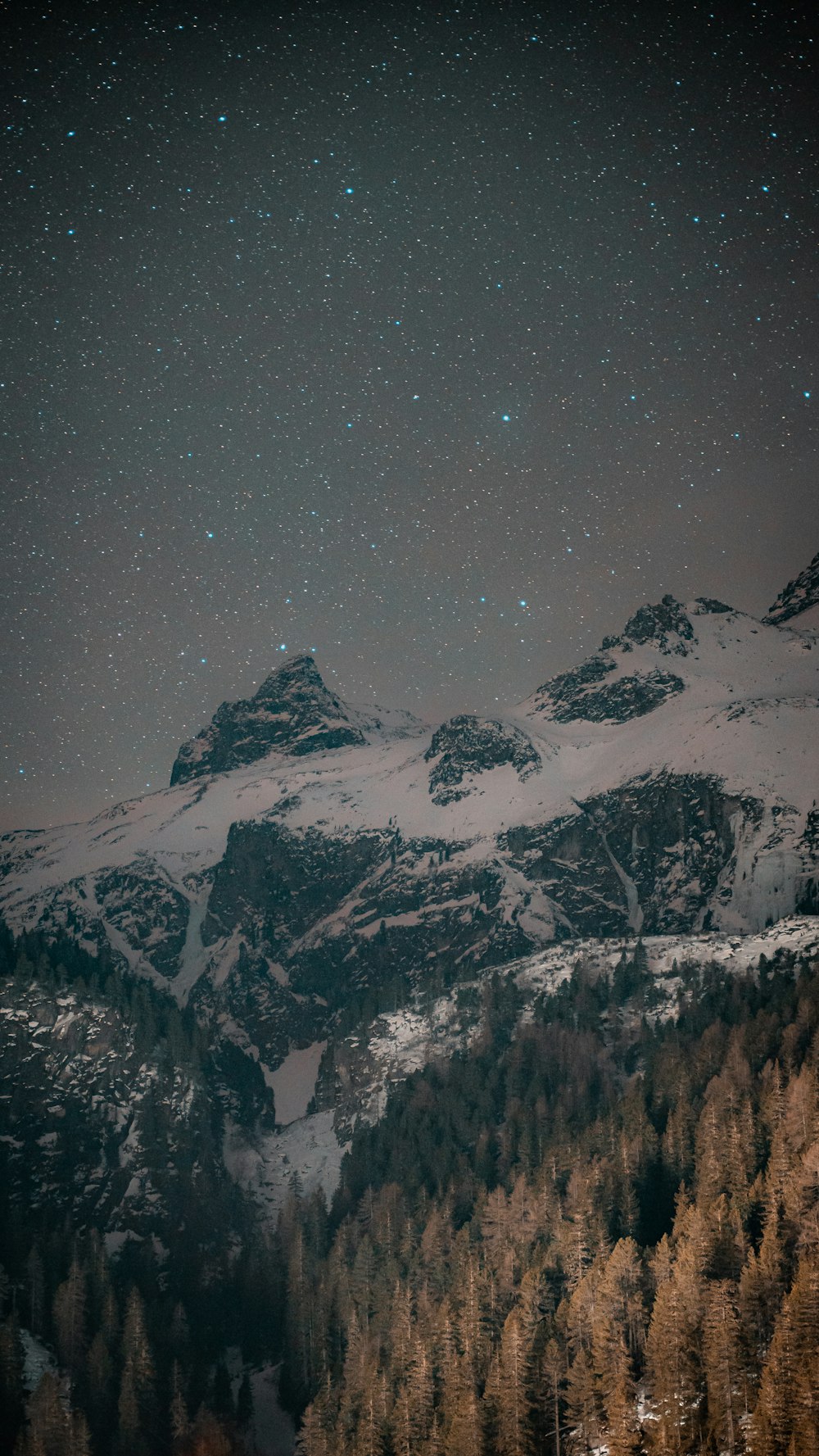 a mountain covered in snow under a night sky