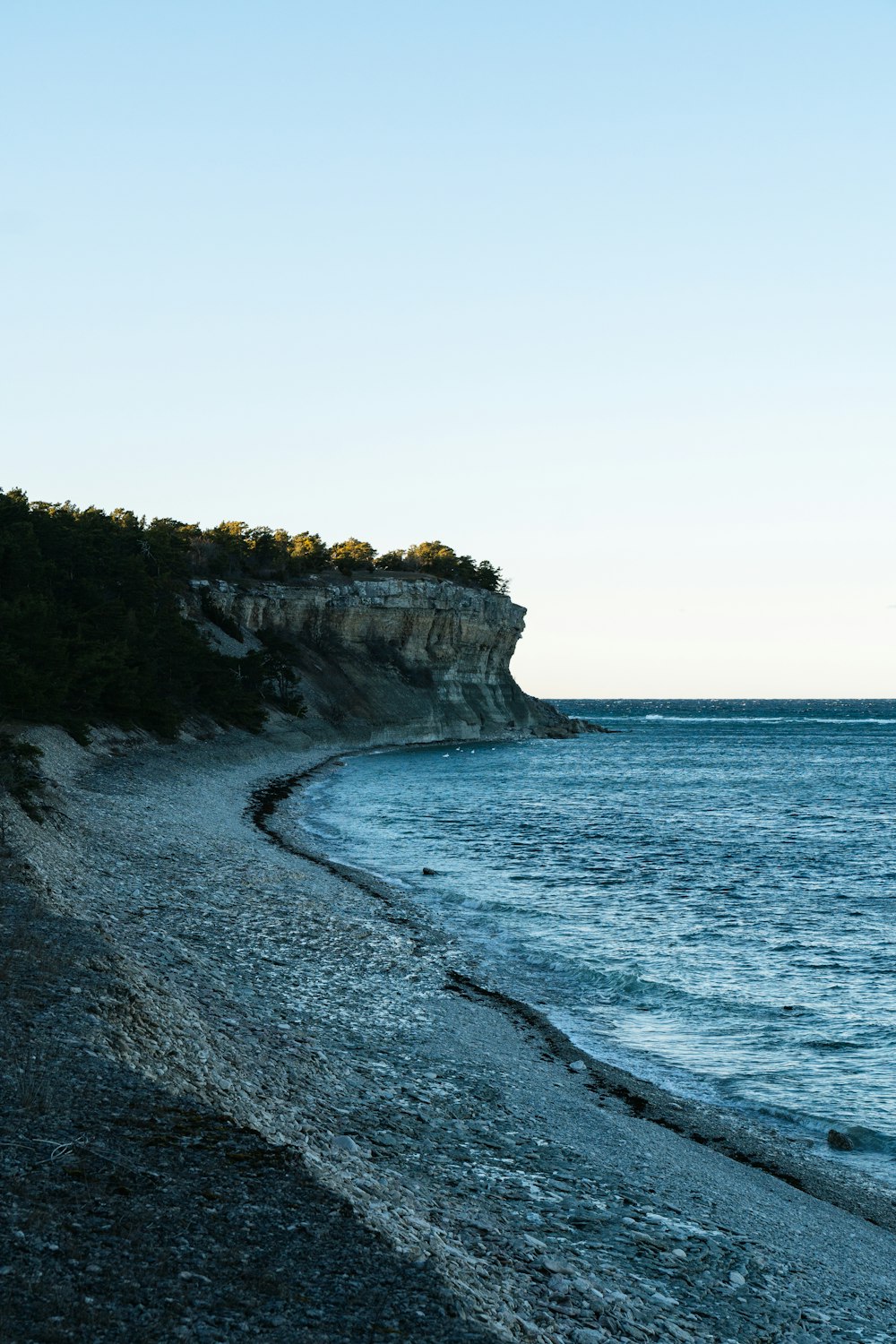 a rocky beach with a cliff in the background