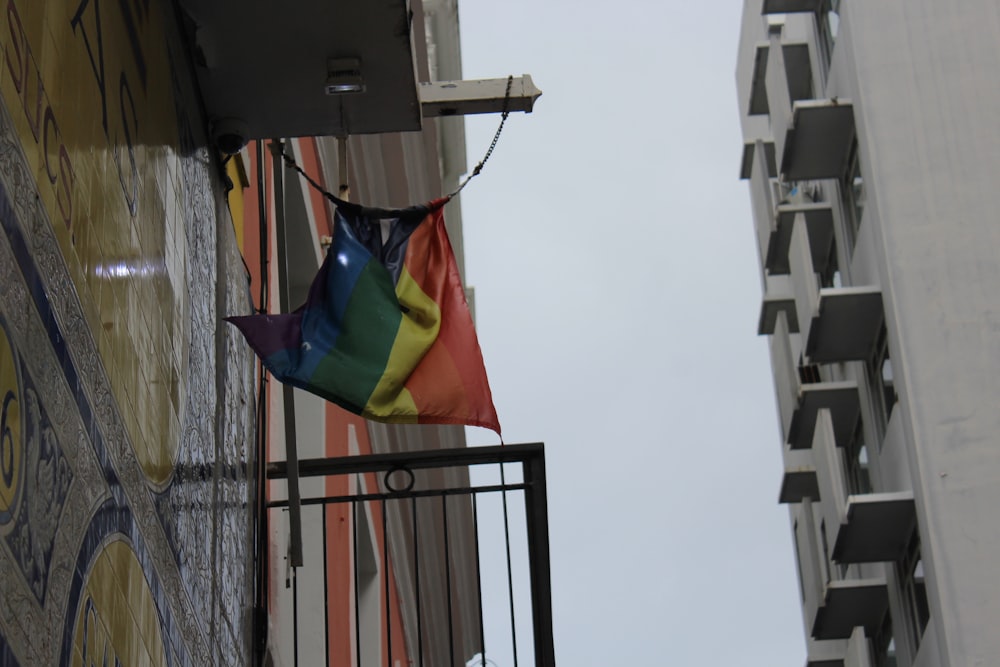 a rainbow flag hanging from the side of a building