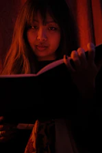 Portrait of Stephanie E. Romer holding her book 'Eye of God: Language of Universal Mind' with a thoughtful expression.