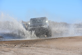 a truck driving through a large puddle of water