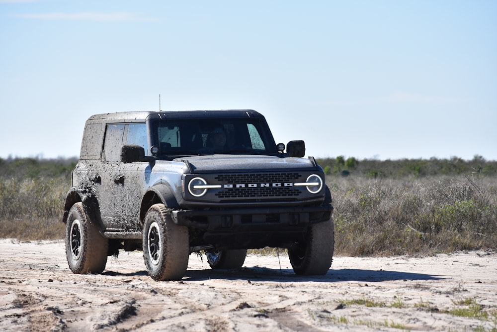 a black truck parked on a dirt road