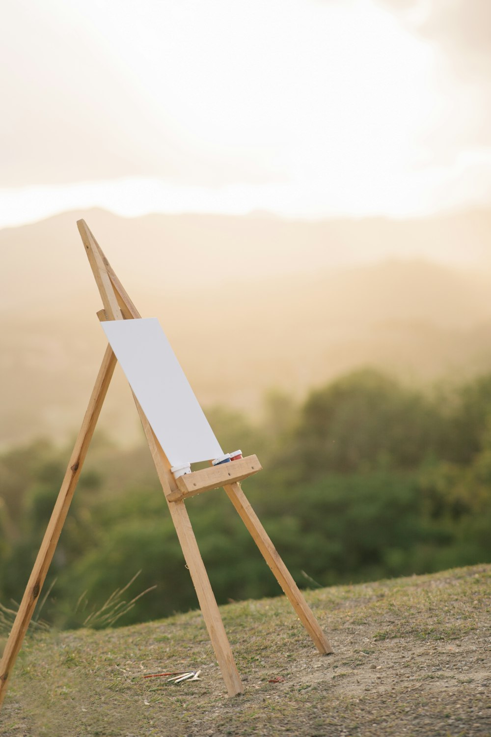 a wooden easel sitting on top of a grass covered field