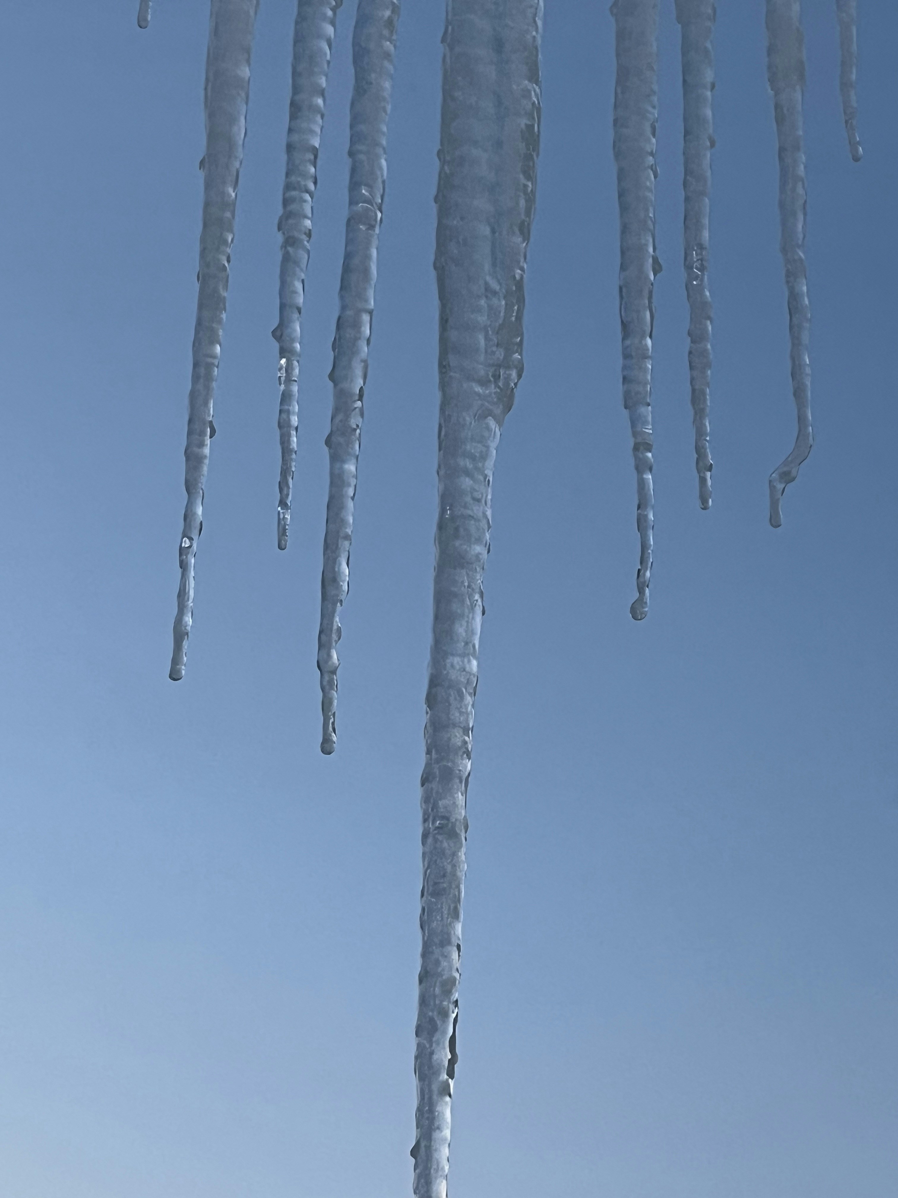 Eine Gruppe von Eiszapfen, die an der Seite eines Gebäudes hängen