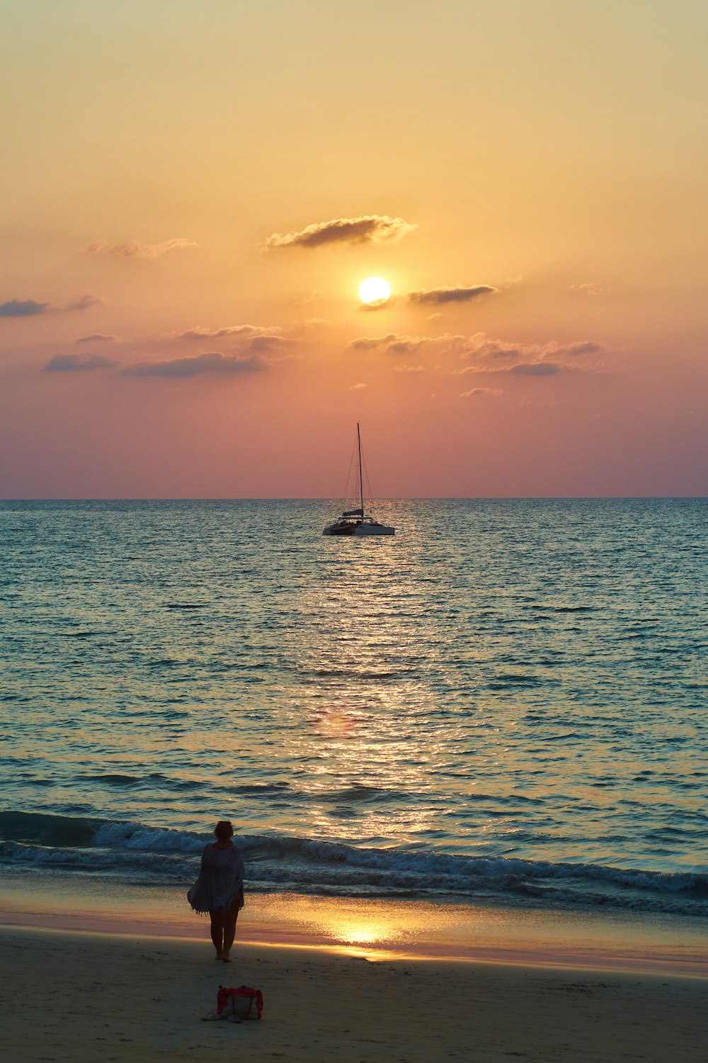 a person walking on the beach at sunset