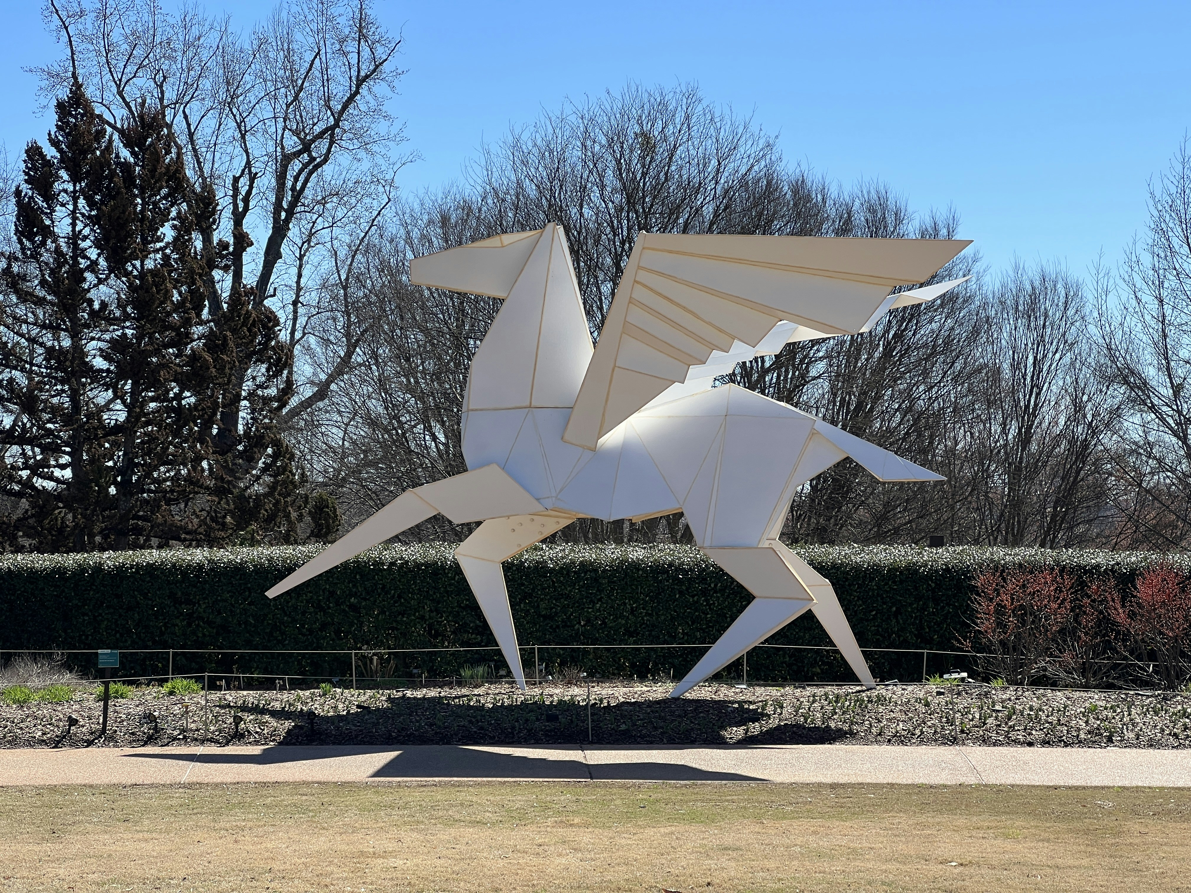 a sculpture of a white horse in a park