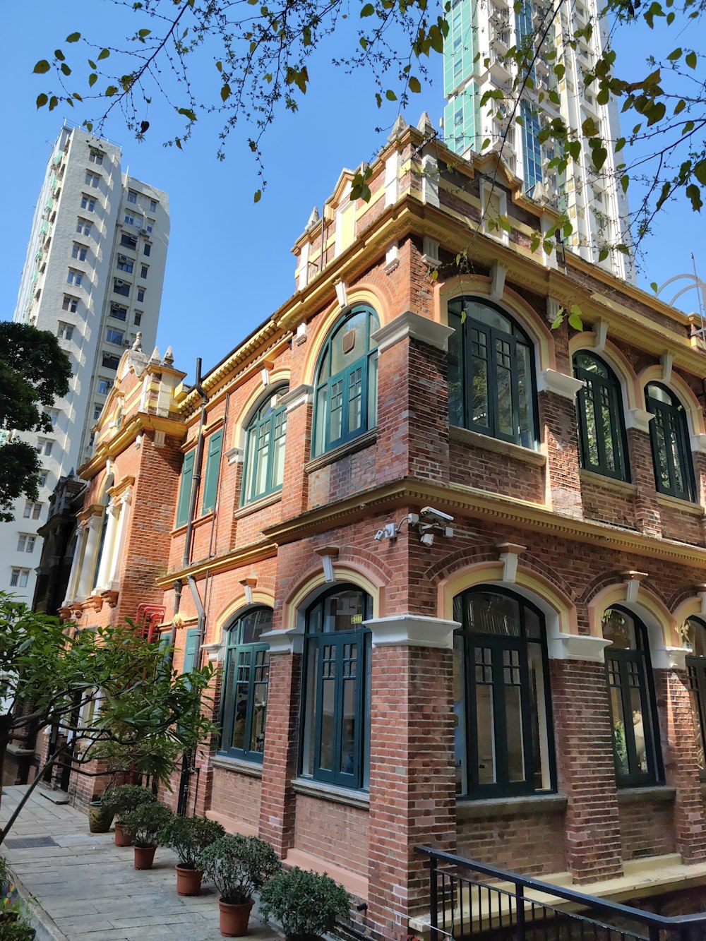 um edifício de tijolos altos com uma torre do relógio no fundo