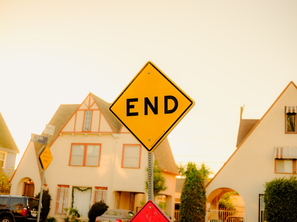 a yellow end sign sitting on the side of a road