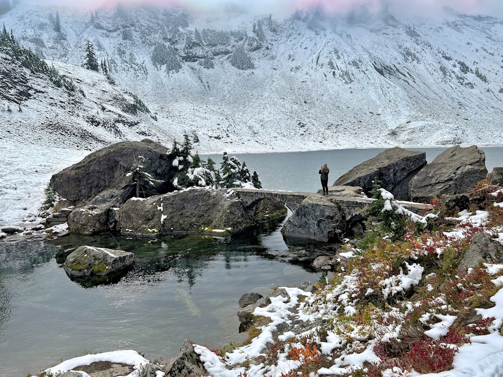 a man standing on a rock in the middle of a lake