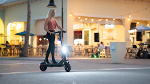 Rider effortlessly cruising on an oxev scooter along a smooth urban path under modern city lights.
