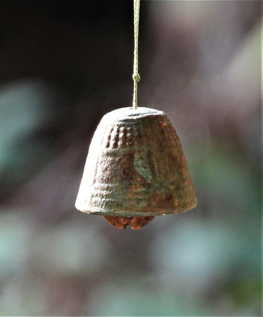 a close up of a bell hanging from a wire