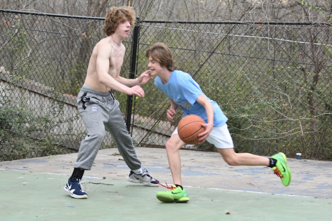 Young players dribbling intensely during a basketball drill on the outdoor turf.