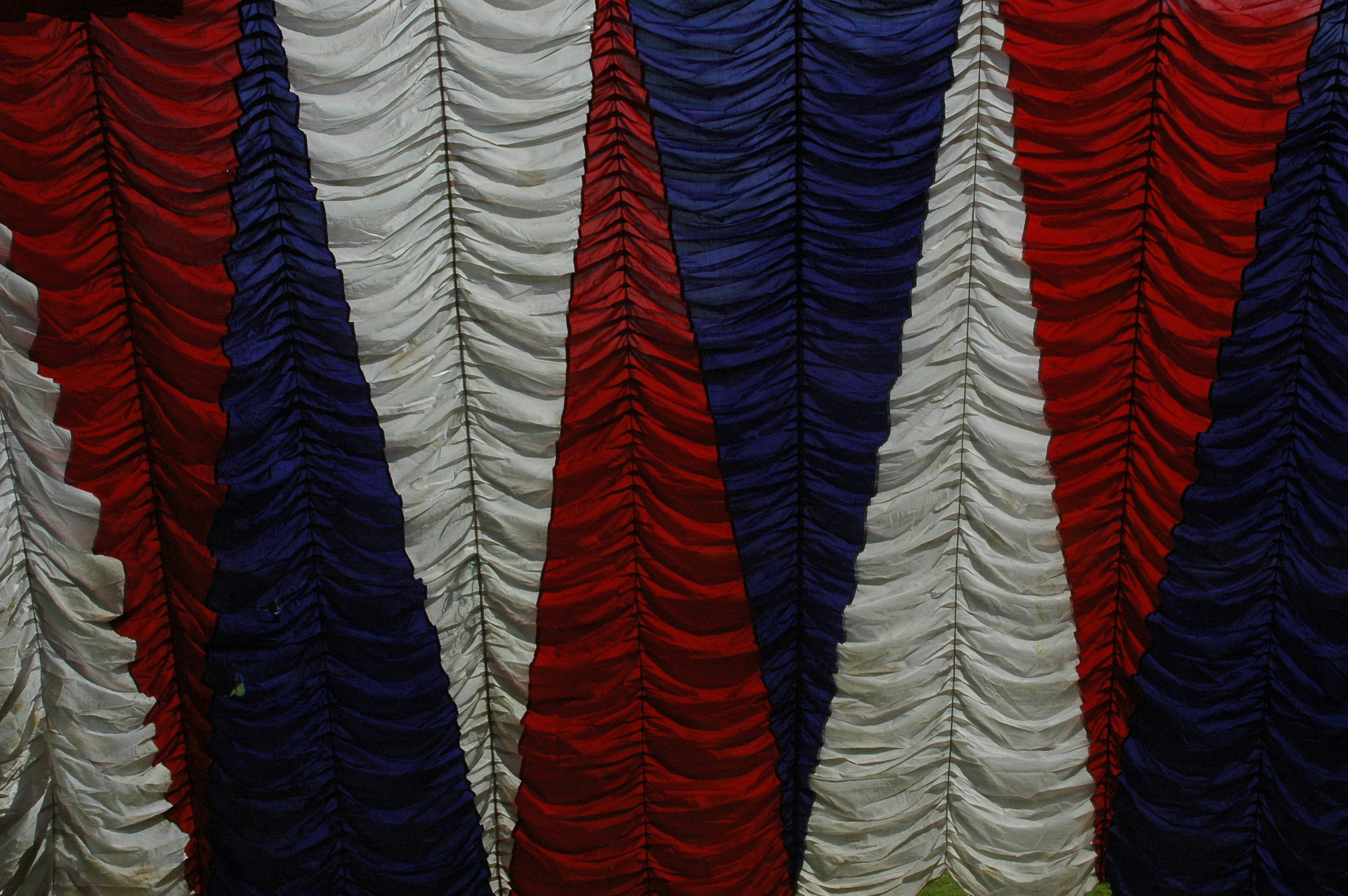a bunch of red, white, and blue feathers hanging from a wall