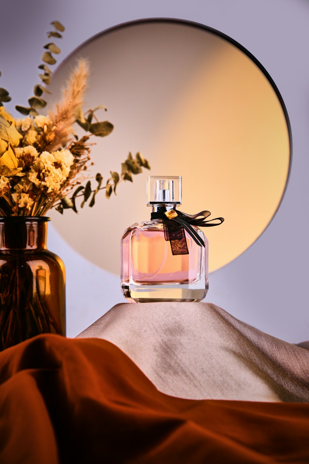 a bottle of perfume next to a vase with flowers