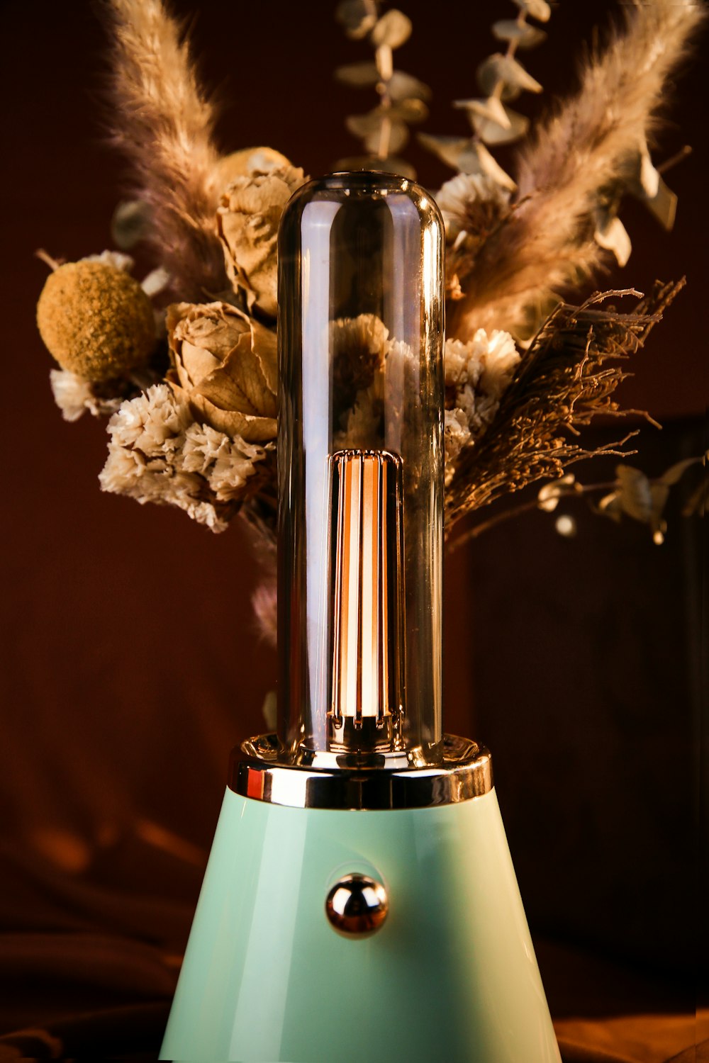 a vase filled with dried flowers on top of a table