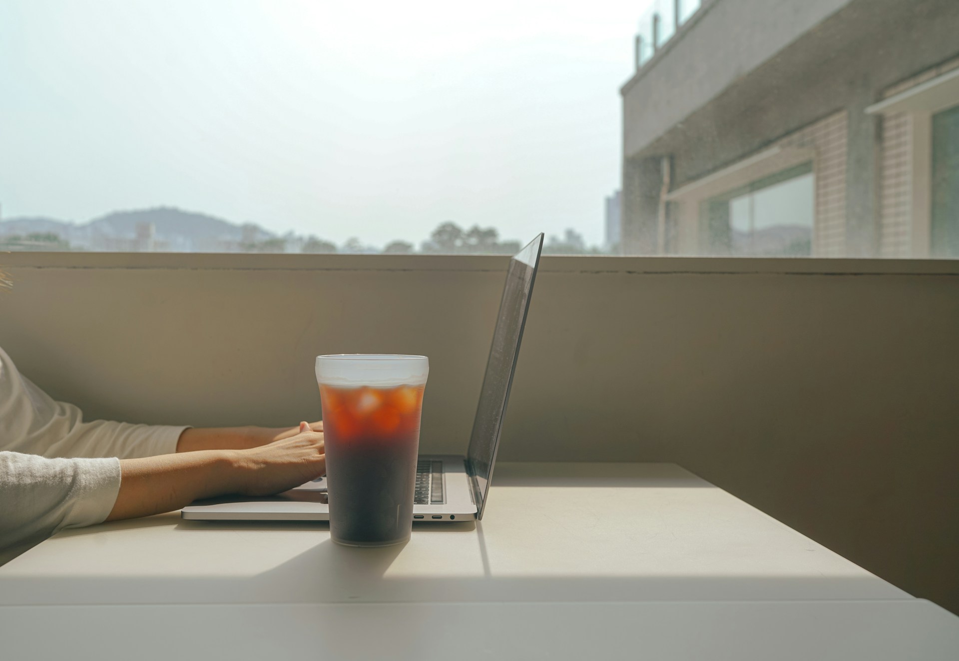 a woman sitting at a table using a laptop computer