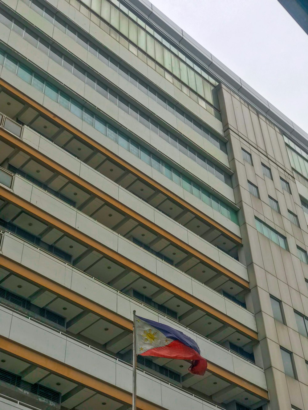 a tall building with a flag flying in front of it