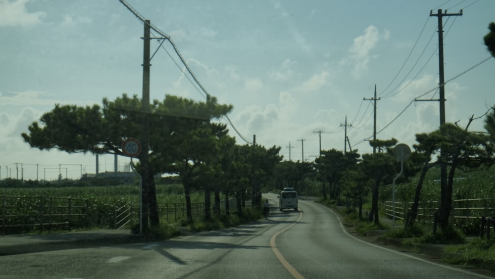 a car driving down a road next to power lines