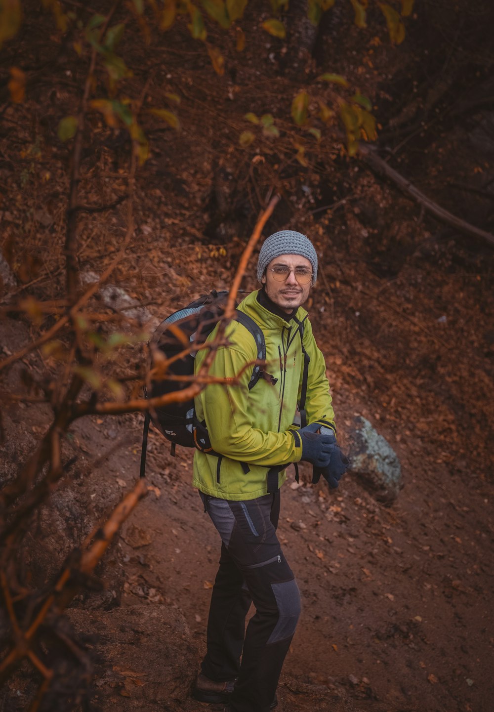 a man in a yellow jacket carrying a backpack