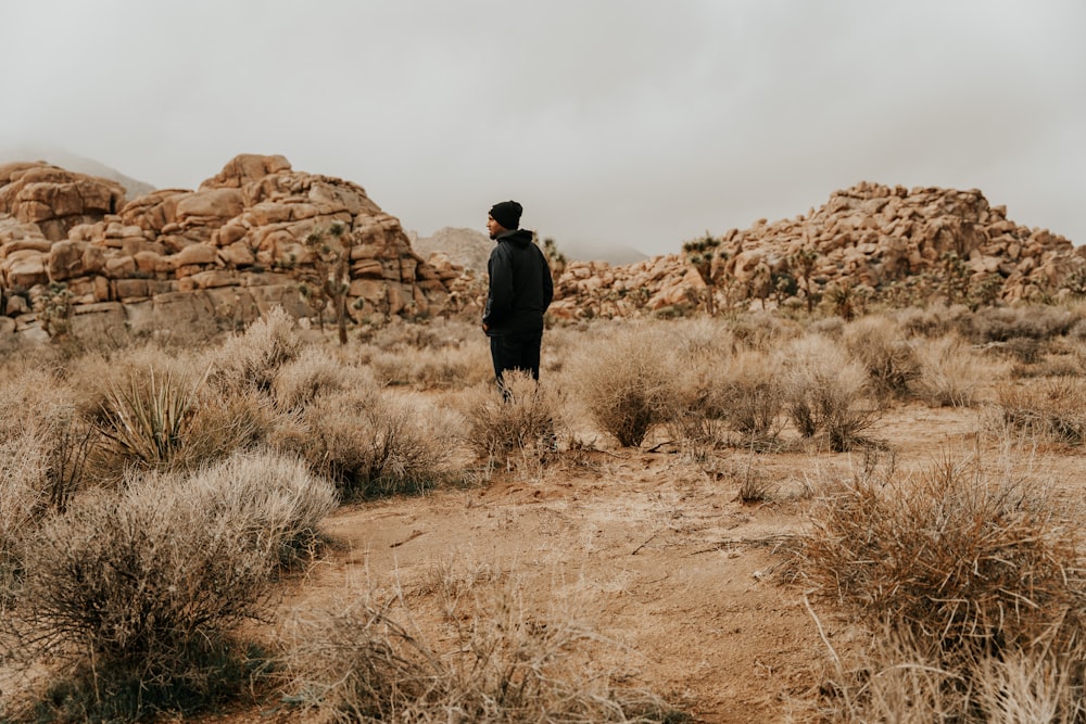 a man standing in the middle of a desert