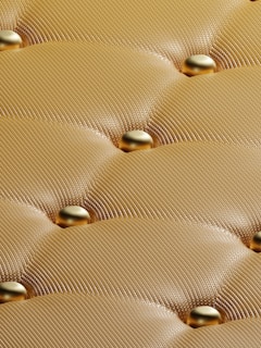 a close up view of a gold colored mattress