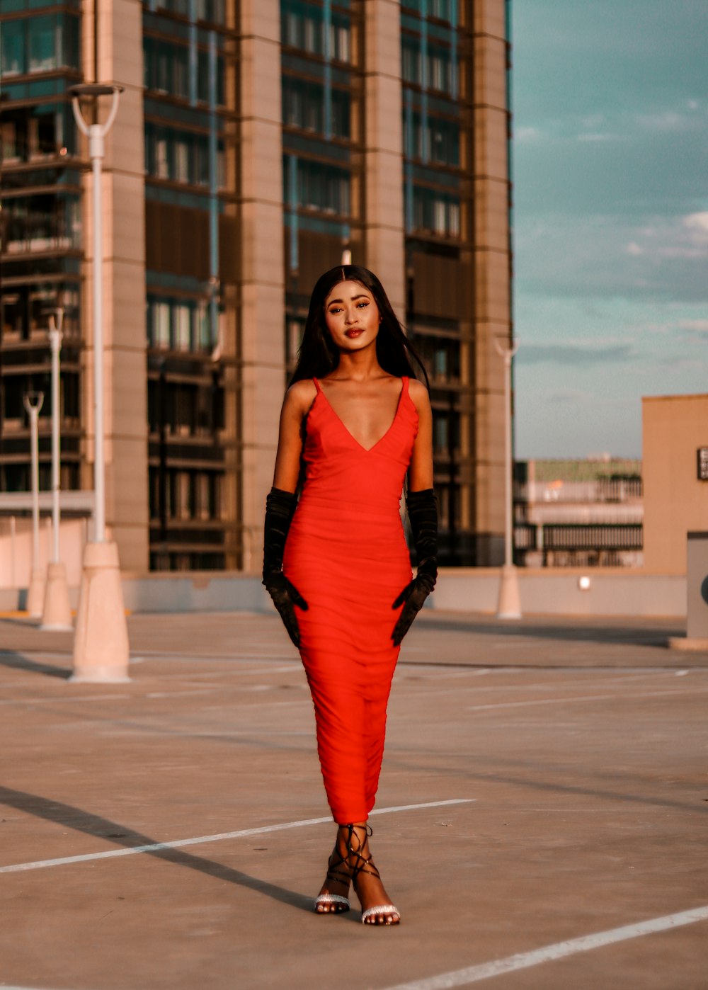 a woman in a red dress and black gloves