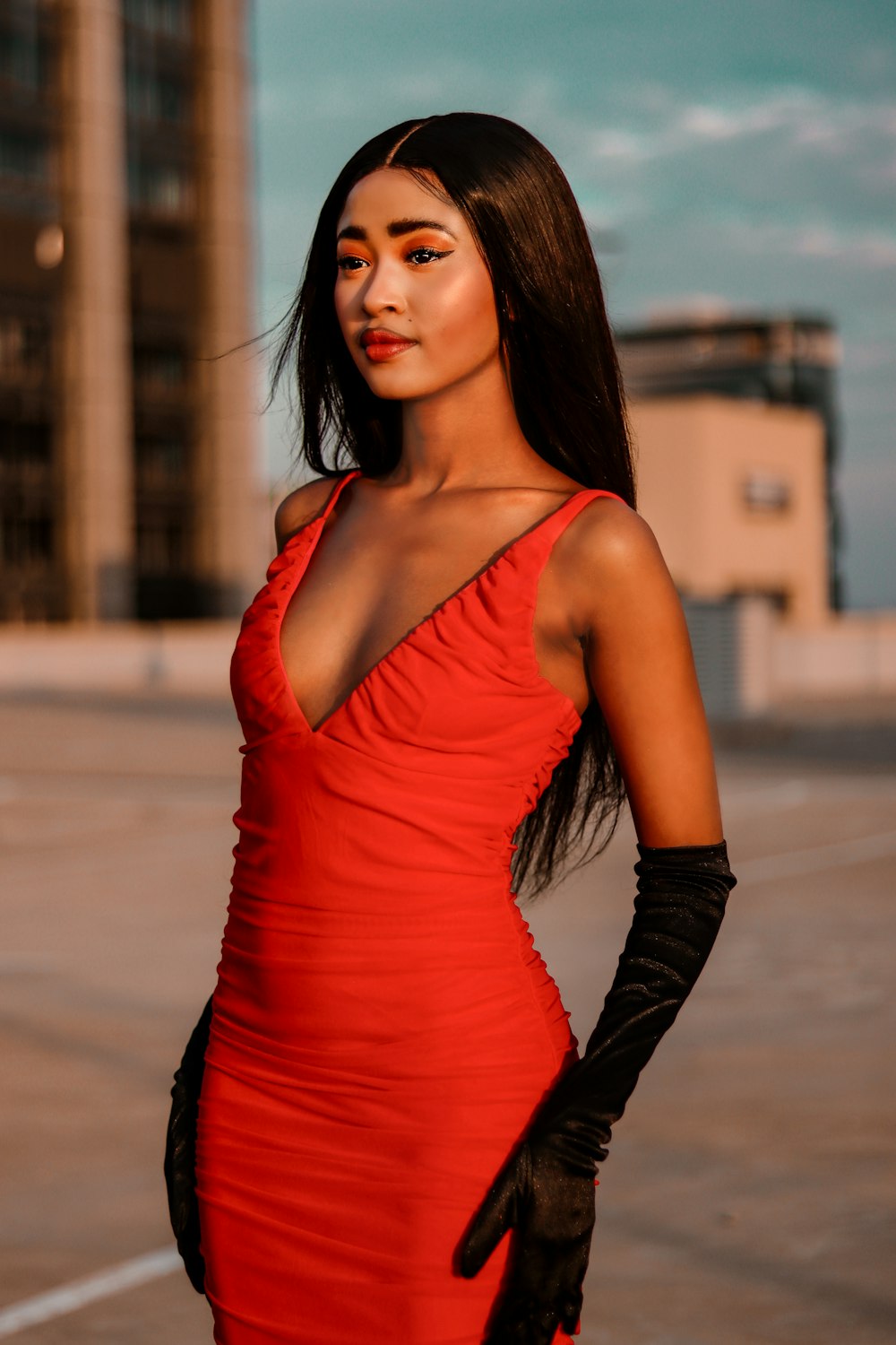 a woman in a red dress and black gloves