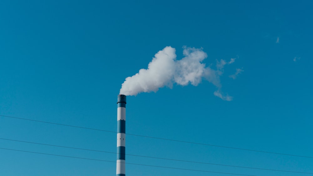 a smokestack emits from a pipe on a clear day