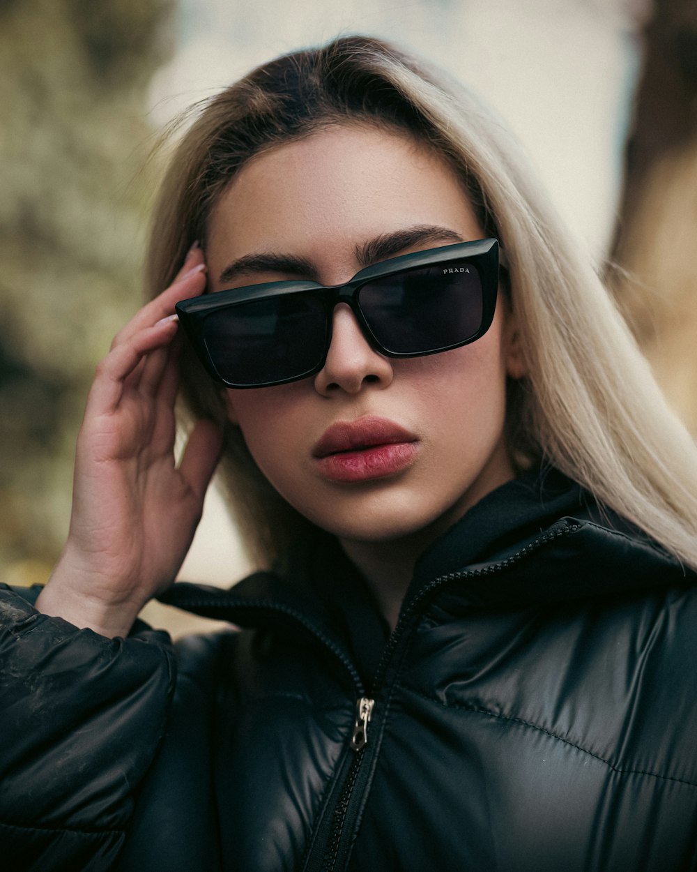 a woman wearing sunglasses and a black jacket
