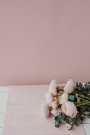A bright, elegant photo of a delicate pink rose bouquet with soft beige background.