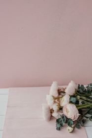 A bright, elegant photo of a delicate pink rose bouquet with soft beige background.