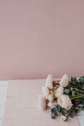Softly lit baby pink rose bouquet resting on a velvet cloth