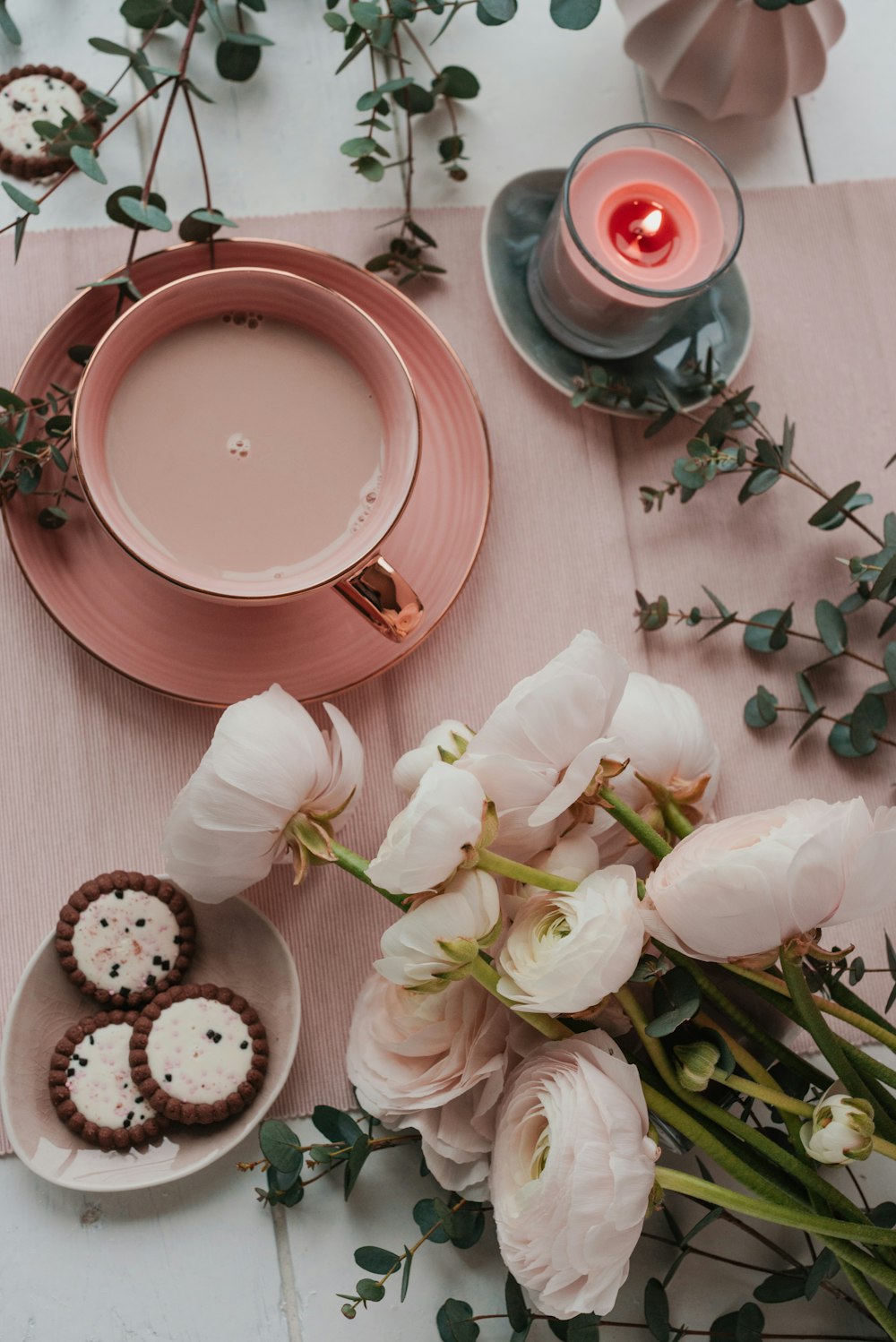 a table topped with pink flowers and plates of food