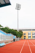 A friendly sports official assisting an athlete near a railway stadium under clear blue skies