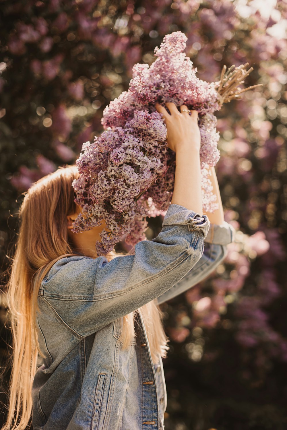 a woman holding a bunch of flowers in front of her face