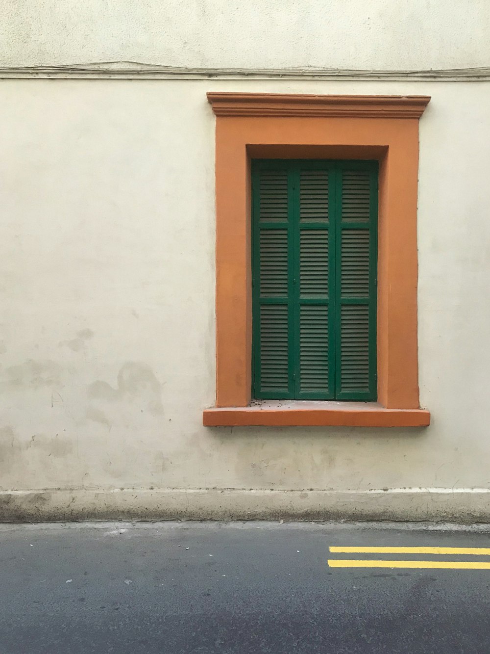 an orange and green window on the side of a building