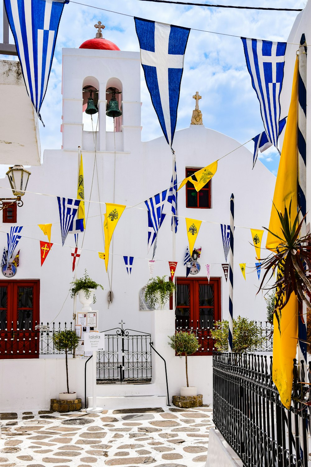 a white building with blue and yellow flags hanging from it's sides