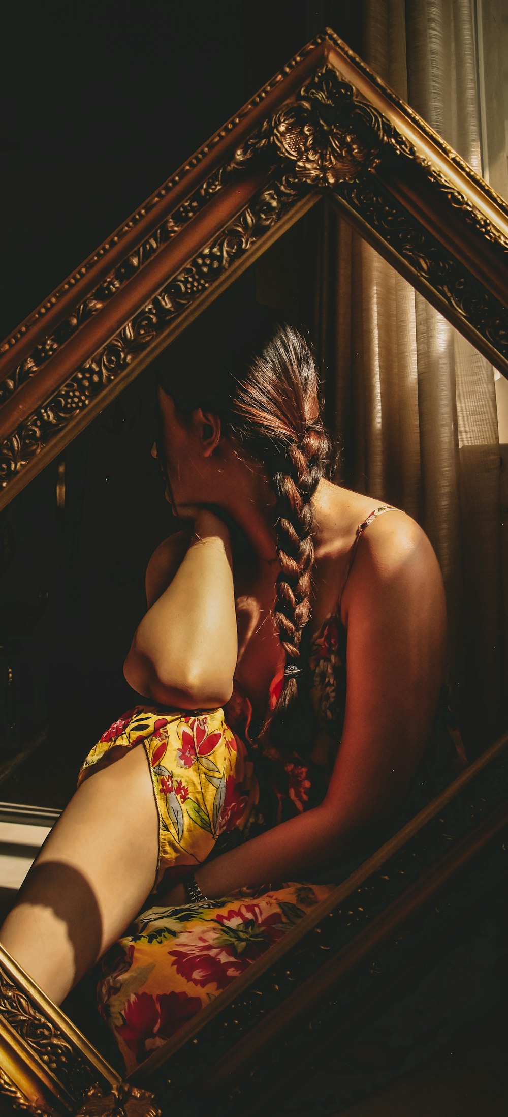 a woman in a floral dress sitting in front of a mirror