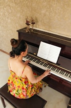 a woman sitting on a bench playing a piano