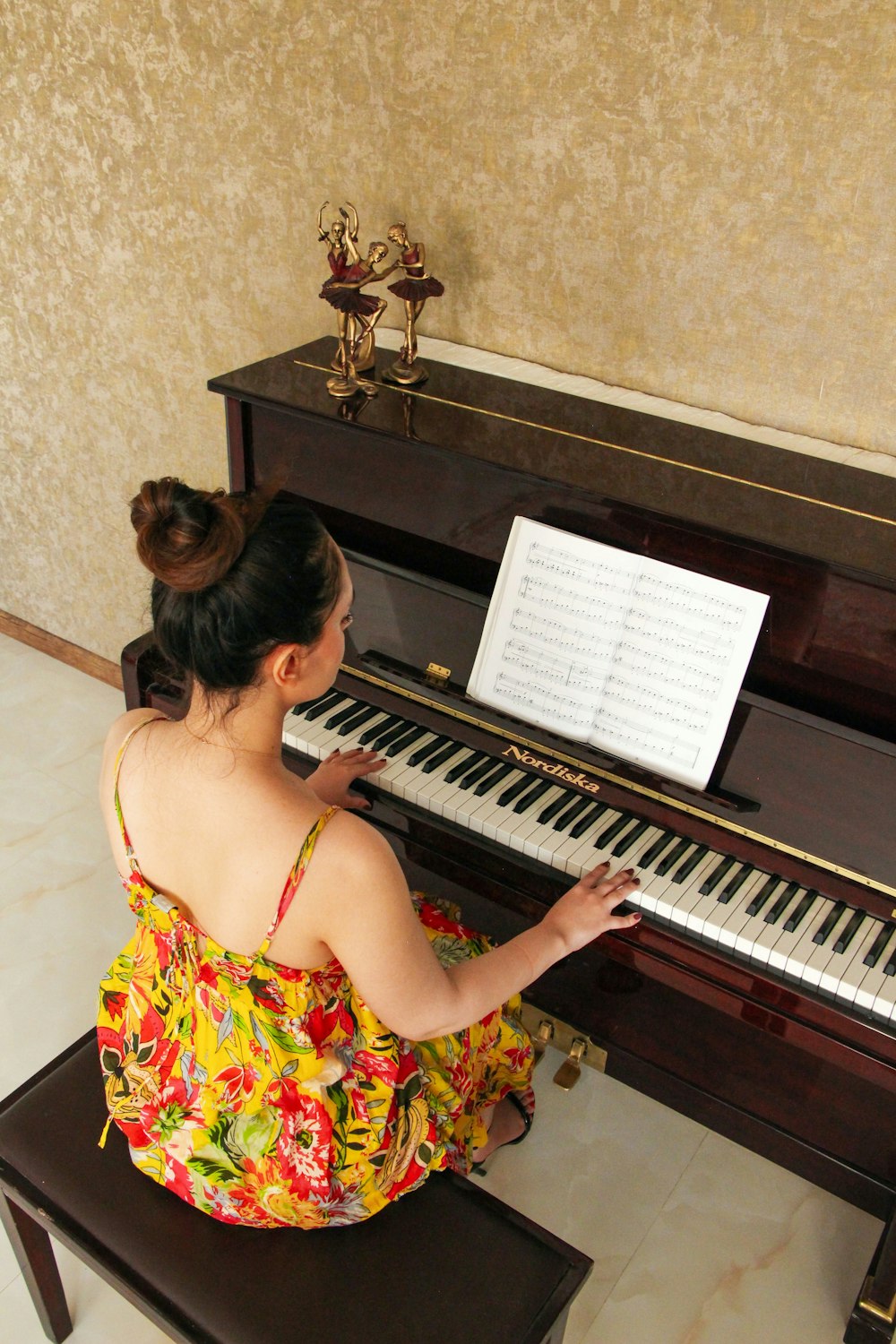 a woman sitting on a bench playing a piano